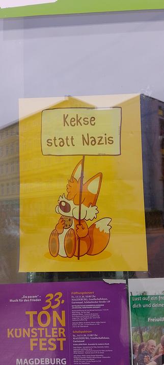 Comiczeichnung eines Fuchs welch ein Keks ist und ein Schild hält "Kekse statt Nazis". Bild ist ausgedruckt und hängt am Schaufenster